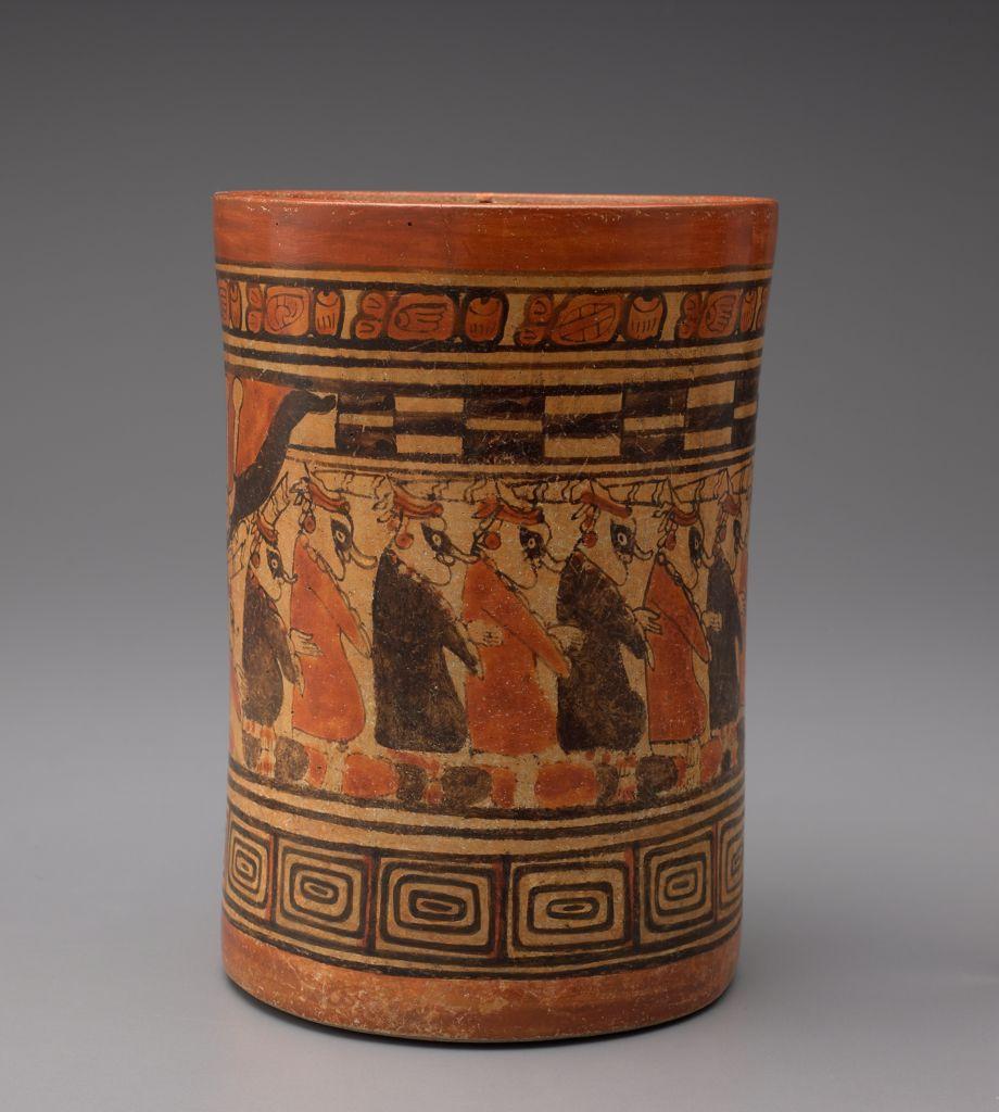 A ceramic vase with repeating, alternating images of stylized human figures wearing black and red robes. They are framed by repeating geometric motifs.